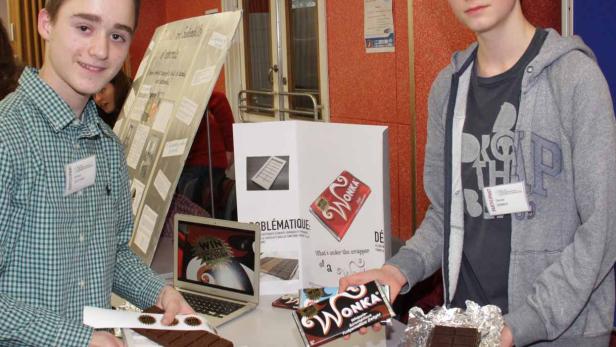 Zwei Jugendliche präsentieren Schokoladenprodukte der Marke „Wonka“ auf einem Tisch.