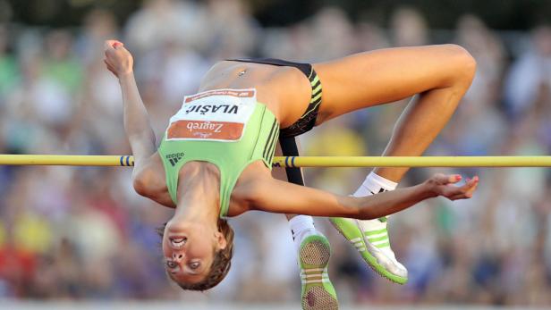 Eine Hochspringerin überquert die Latte bei einem Wettkampf.