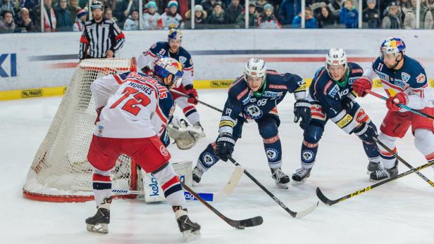 Eishockeyspieler kämpfen um den Puck vor dem Tor.