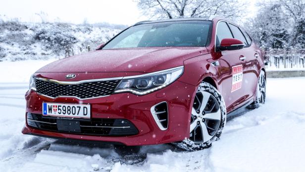 Ein roter Kia steht im Schnee.