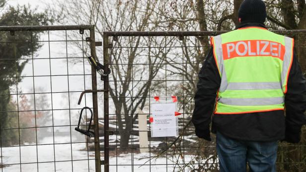 Ein Polizist steht vor dem abgesperrten Grundstück bei Würzburg