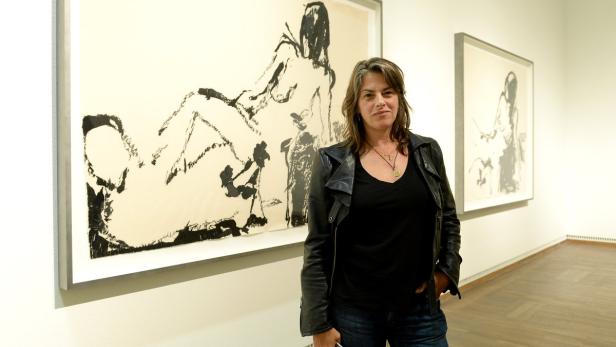 Eine Frau steht vor zwei großformatigen Zeichnungen in einer Kunstgalerie.