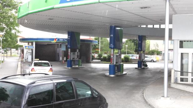 Eine Tankstelle der Marke OMV mit mehreren Zapfsäulen und einem Taxi.
