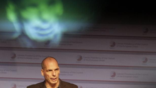 Yan Varoufakis spricht vor einem Hintergrund mit dem Logo der lettischen EU-Ratspräsidentschaft.