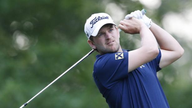 Ein Golfspieler schwingt seinen Schläger auf einem Golfplatz.