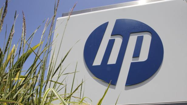 Das blaue HP-Logo an einem Gebäude, teilweise von Gras verdeckt.