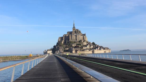 Mont-Saint-Michel, eine Gezeiteninsel in der Normandie, Frankreich, gesehen von einem Steg aus.