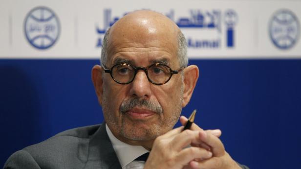 Ein Mann mit Brille und Anzug hält einen Stift in der Hand.