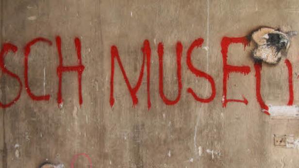 Die rote Aufschrift „Nitsch Museum“ auf einer beigen Wand.