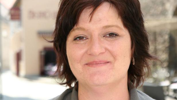 Porträt einer lächelnden Frau mit braunen Haaren.