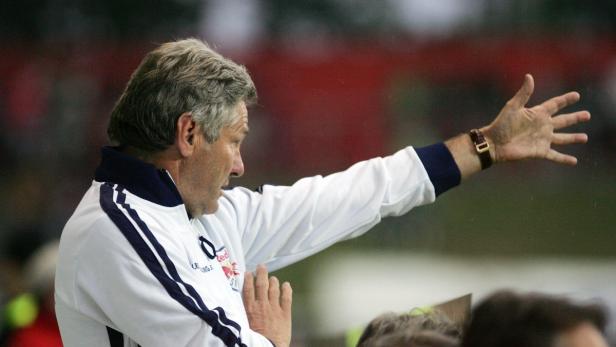 Ein Trainer gestikuliert während eines Fußballspiels.