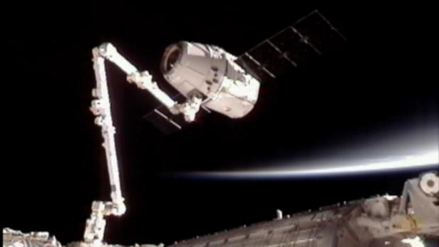 dapdThis image provided by NASA-TV shows the SpaceX Dragon commercial cargo craft, top, after Dragon was grappled by the Canadarm2 robotic arm and connected to the International Space Station, Friday, May 25, 2012. Dragon is scheduled to spend about a wee Dragon Raumkapsel erreicht ISS