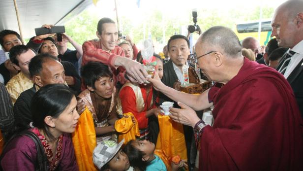 Der Dalai Lama interagiert mit einer Menschenmenge.