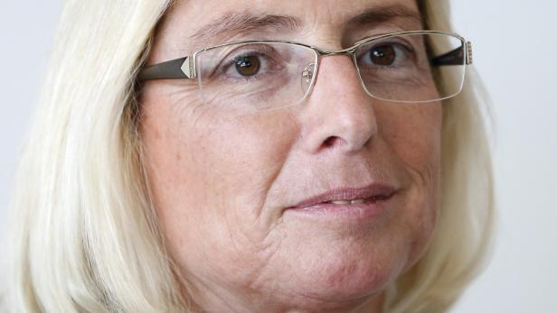 Porträt einer Frau mit blonden Haaren und Brille.