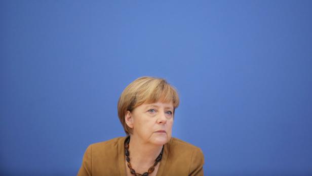Angela Merkel vor einem blauen Hintergrund.