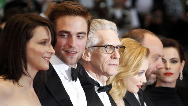 Eine Gruppe von Schauspielern, darunter Juliette Binoche und Robert Pattinson, posiert auf einem Event.