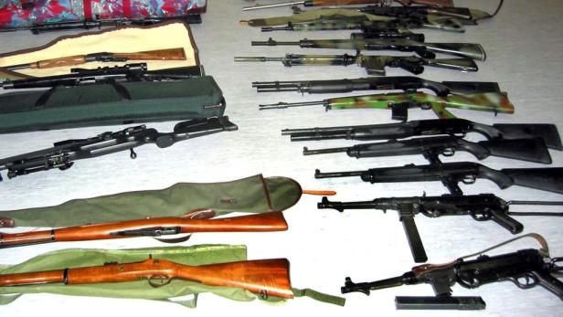 Eine Sammlung von verschiedenen Gewehren und Schusswaffen liegt auf einem Tisch.