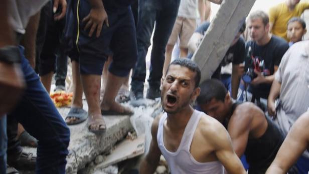 Palästinenser suchen in den Trümmern der Gebäude nach Überlebenden und Todesopfer