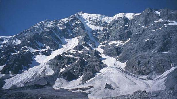 Ein schneebedeckter Berg unter einem blauen Himmel.