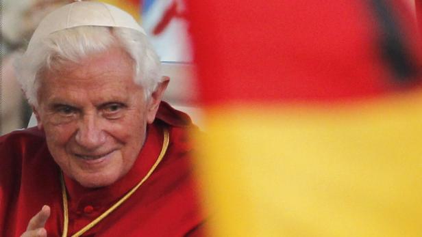Papst Benedikt XVI. vor einer Deutschlandflagge.