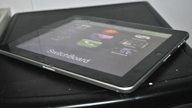 Ein iPad liegt auf einer schwarzen Oberfläche.