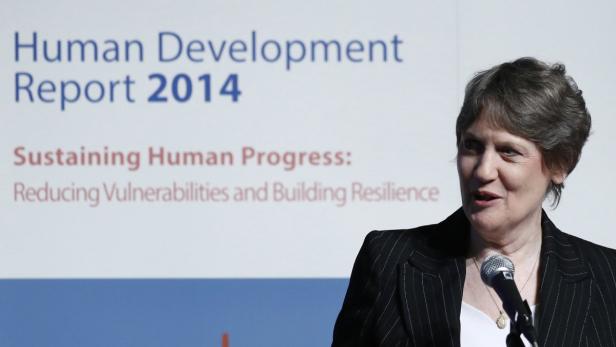 Eine Frau spricht vor dem Hintergrund des „Human Development Report 2014“.