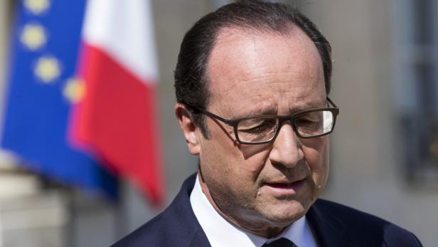 François Hollande vor der französischen und der europäischen Flagge.