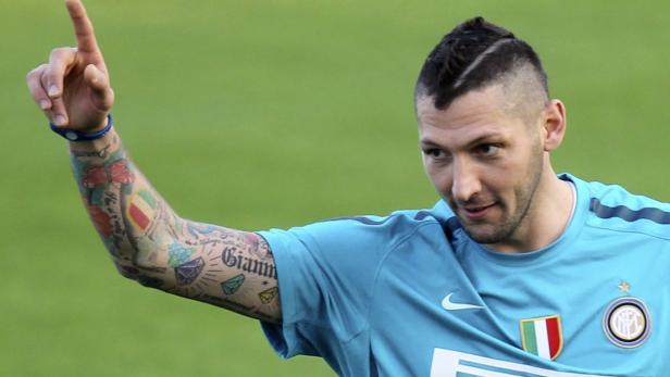 Ein tätowierter Fußballspieler von Inter Mailand zeigt mit dem Finger nach oben.