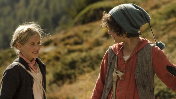 Ein Mädchen mit Zöpfen und ein Junge mit Mütze schauen sich an.