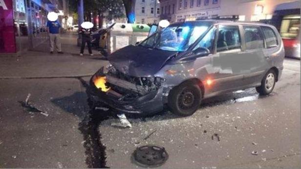Ein beschädigtes Auto steht auf einer Straße, übersät mit Trümmern.