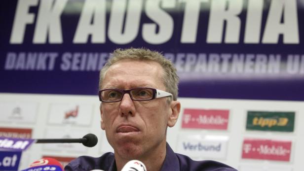 Ein Mann mit Brille steht vor einem FK Austria Hintergrund.