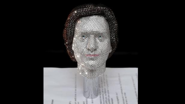 Eine Büste, die vollständig mit glitzernden Strasssteinen bedeckt ist.