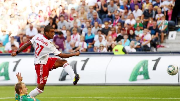 Ein Fußballspieler von Red Bull schießt den Ball vor einer Zuschauermenge.