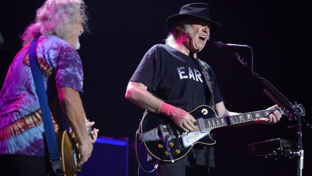 Neil Young spielt Gitarre und singt auf der Bühne.