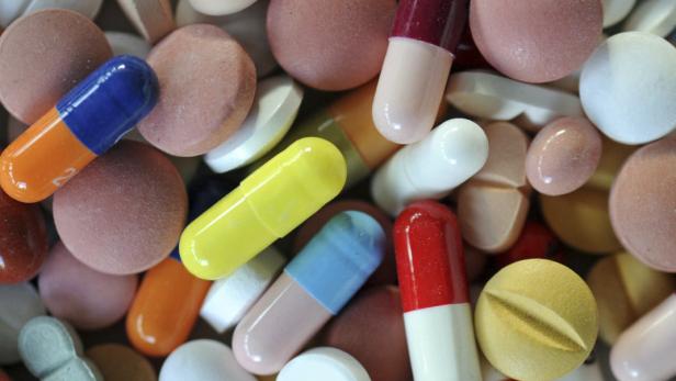 Verschiedenfarbige Pillen und Kapseln liegen dicht aneinander.