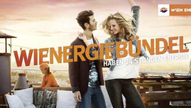 Ein Paar feiert auf einer Dachterrasse mit dem Slogan „Wiener Energie Bündel haben 24 Stunden Energie“.