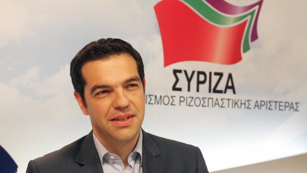 Alexis Tsipras, griechischer Politiker, vor einem Hintergrund mit dem Logo von SYRIZA.