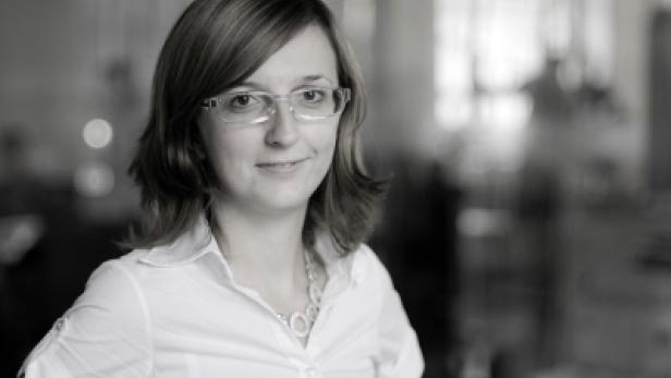 Porträt einer Frau mit Brille und weißem Hemd in Schwarzweiß.