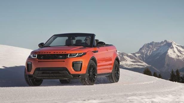 Ein orangefarbener Range Rover Evoque Cabriolet fährt durch eine verschneite Landschaft.