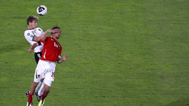 Zwei Fußballspieler kämpfen um den Ball in der Luft.