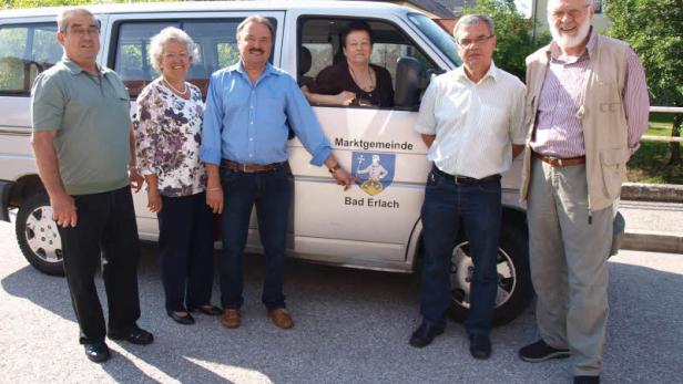 Eine Gruppe von sechs Personen steht vor einem Lieferwagen der Marktgemeinde Bad Erlach.