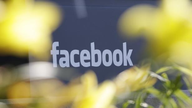 Das Facebook-Logo ist durch gelbe Blumen hindurch zu sehen.