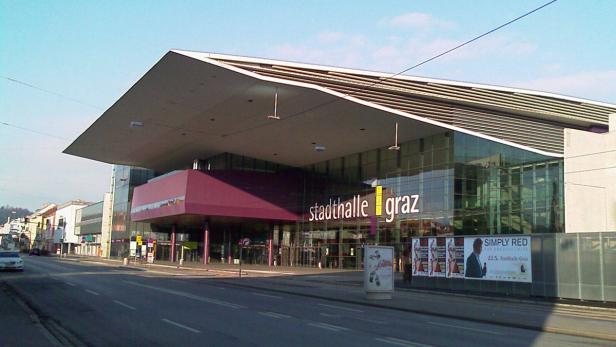 Die Stadthalle Graz, ein modernes Gebäude mit Glasfassade, an einer Straße.