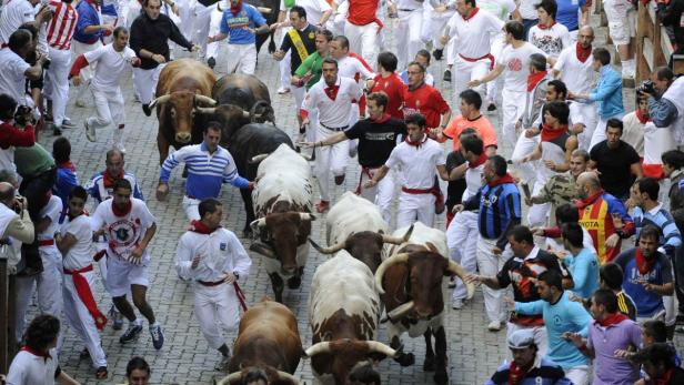 Beim San Fermín-Fest rennen Menschen vor Stieren durch die Straßen von Pamplona.