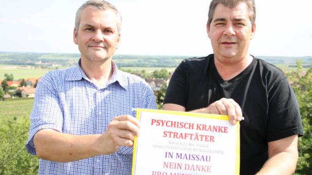 Zwei Männer halten ein Schild mit der Aufschrift „Psychisch kranke Straftäter in Maissau – Nein Danke“.