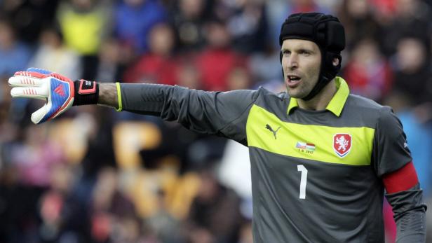 Petr Čech, tschechischer Torwart mit Helm, zeigt mit seiner behandschuhten Hand nach rechts.