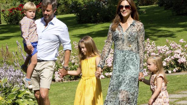 Kronprinzessin Mary und Kronprinz Frederik mit ihren Kindern in einem Garten.