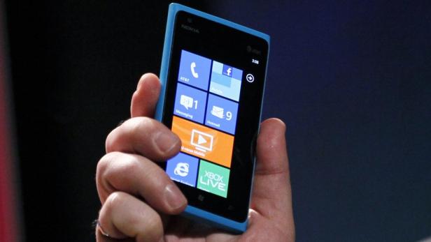 Eine Hand hält ein blaues Nokia Smartphone mit Windows Phone Betriebssystem.