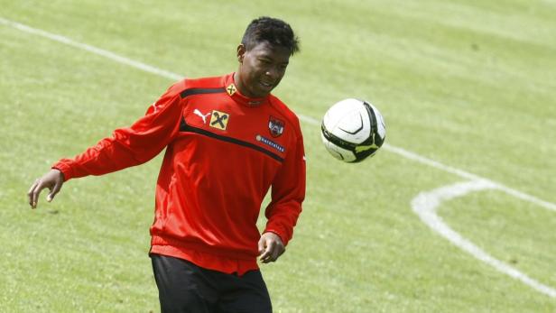 David Alaba mit einem Fußball auf einem grünen Rasen.