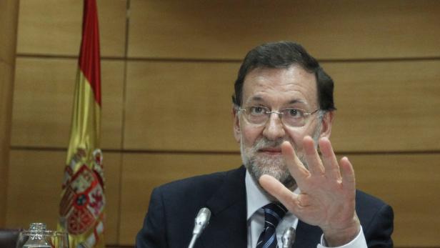 Mariano Rajoy spricht vor einer spanischen Flagge.